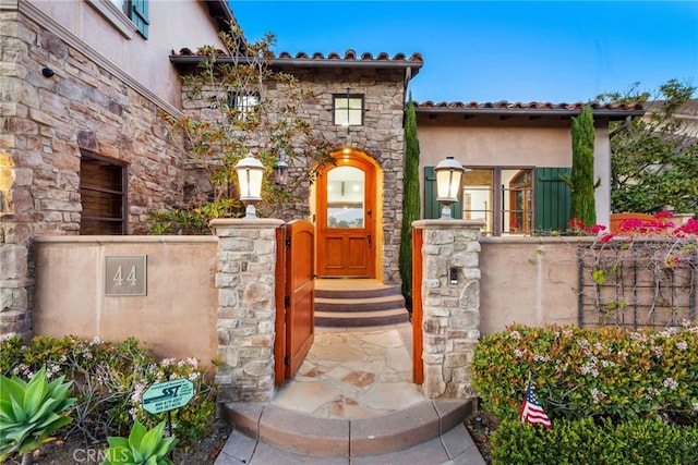 entrance to property with stone siding and stucco siding