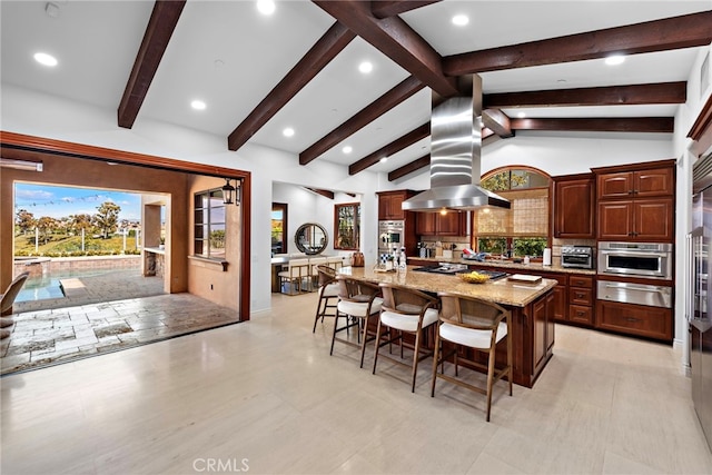 kitchen featuring a warming drawer, island exhaust hood, a spacious island, lofted ceiling with beams, and a kitchen breakfast bar