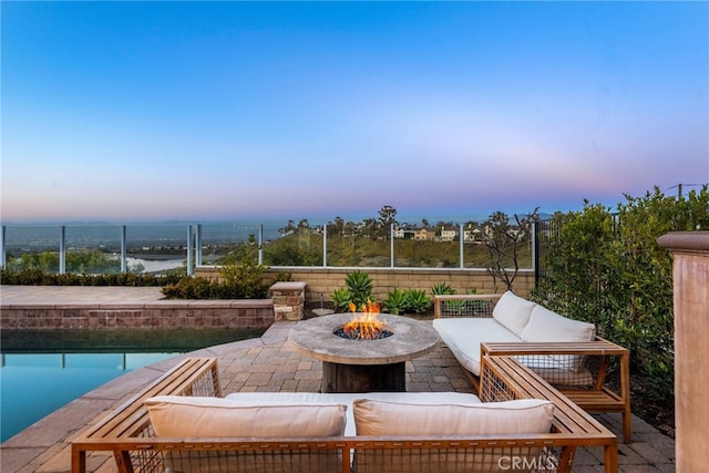 view of patio / terrace featuring an outdoor living space with a fire pit, fence, and a water view