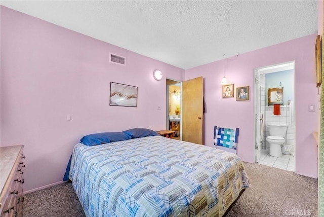 bedroom with light carpet, ensuite bath, visible vents, and a textured ceiling