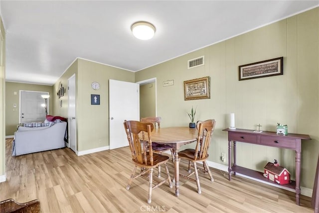 dining room with light wood-type flooring, baseboards, and visible vents