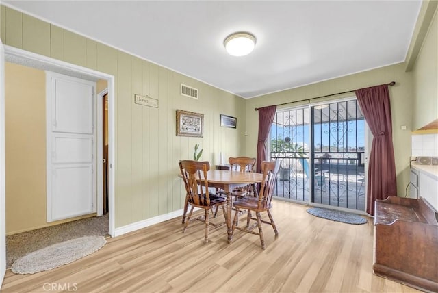 dining room featuring light wood finished floors, visible vents, and baseboards