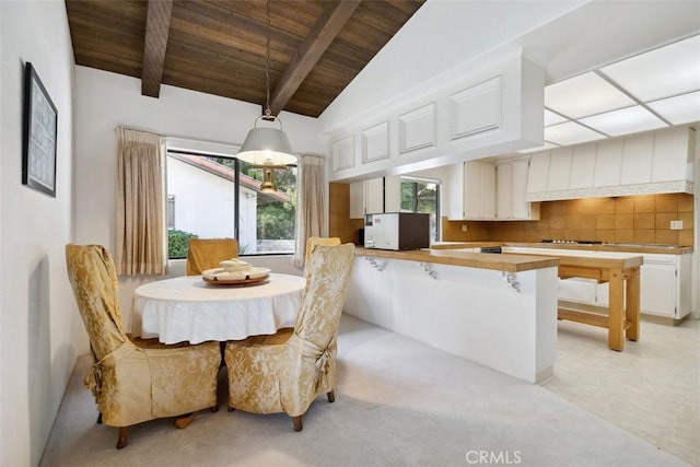 dining room featuring vaulted ceiling with beams and wooden ceiling