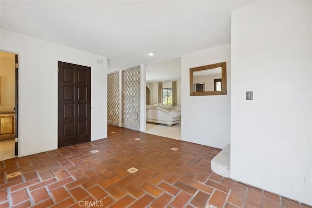 spare room featuring brick floor and recessed lighting