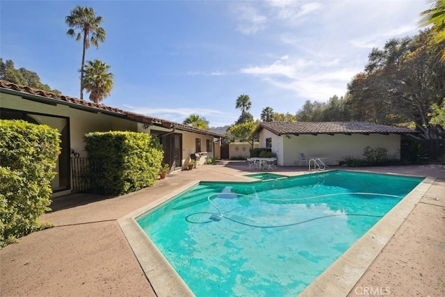 outdoor pool with a patio and fence