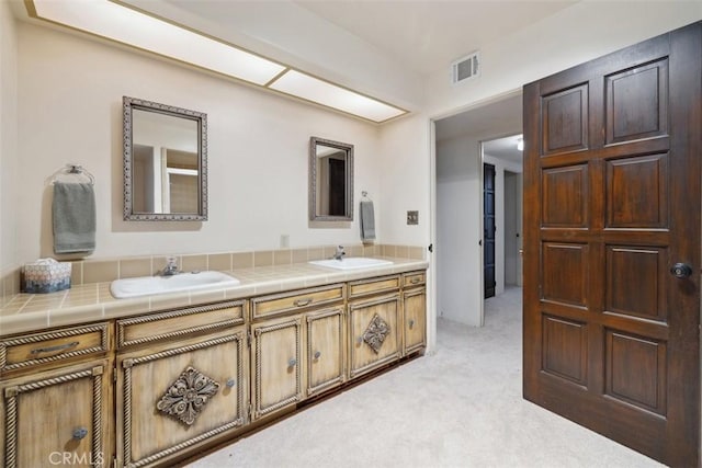 bathroom with double vanity, a sink, and visible vents