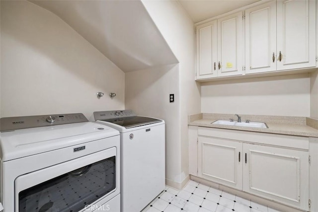 washroom featuring cabinet space, separate washer and dryer, a sink, and light floors