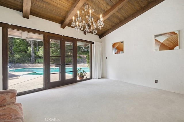 entryway featuring french doors, vaulted ceiling with beams, wood ceiling, carpet flooring, and a chandelier