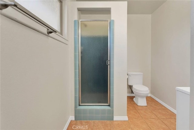 full bathroom with a stall shower, baseboards, tile patterned flooring, and toilet