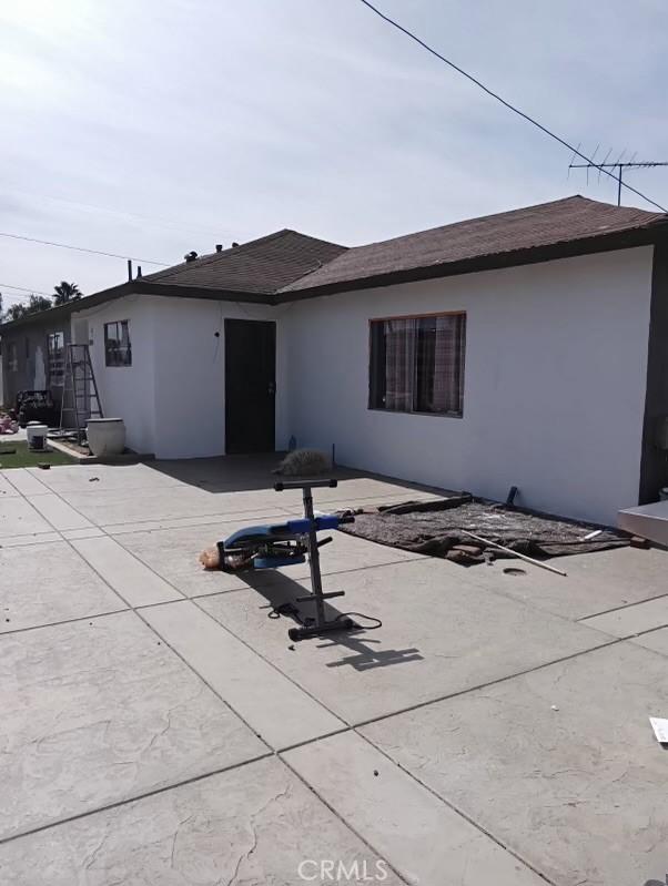 rear view of property featuring a patio and stucco siding