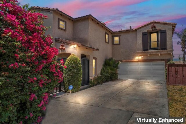 1339 Castledale St, Riverside, CA 92501 - mediterranean / spanish house featuring a garage, stucco siding, a tiled roof, and concrete driveway