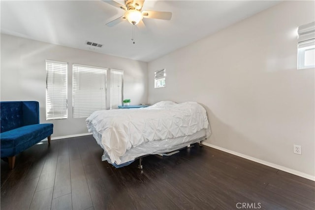 bedroom featuring dark wood-style floors, visible vents, baseboards, and a ceiling fan