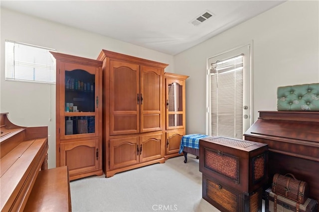 sitting room featuring visible vents and light colored carpet