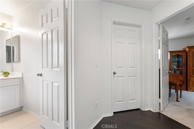 hall with baseboards and wood finished floors