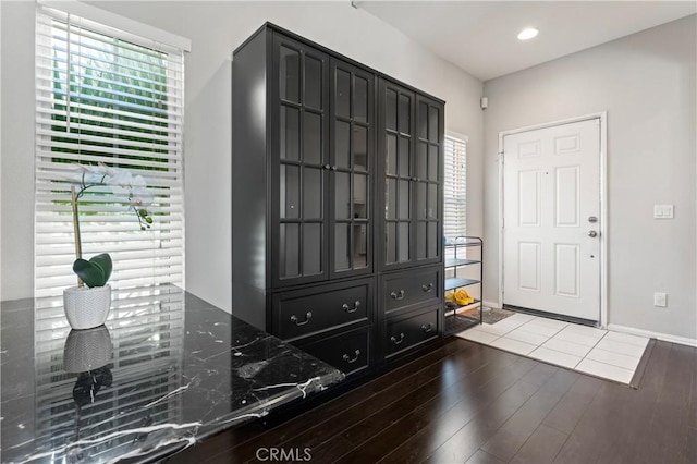 foyer entrance with baseboards, wood finished floors, and recessed lighting