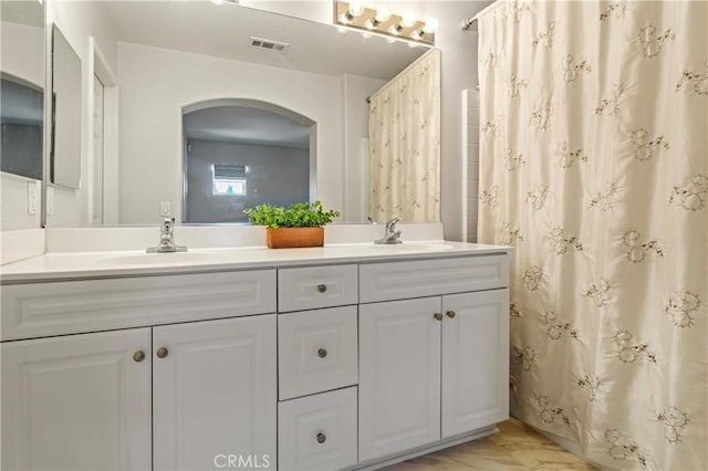 full bathroom with visible vents, a sink, and double vanity