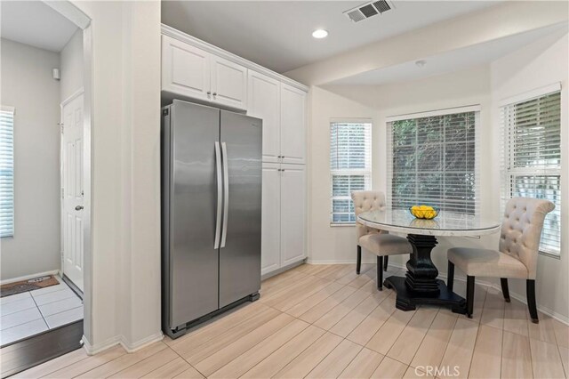 1339 Castledale St, Riverside, CA 92501 - kitchen with white cabinets, freestanding refrigerator, recessed lighting, baseboards, and visible vents