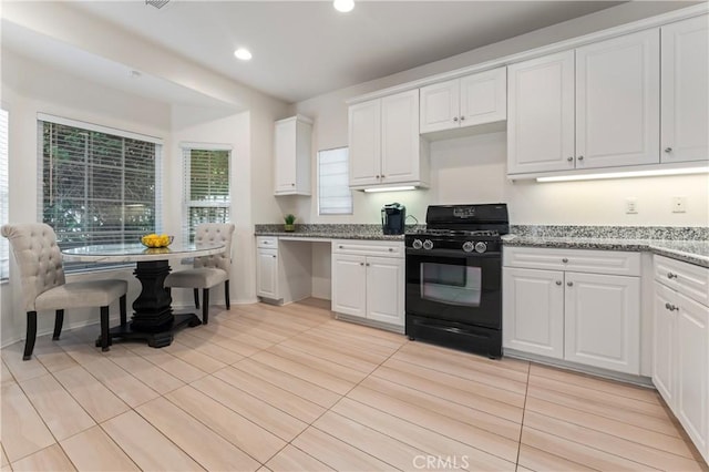 kitchen featuring light stone counters, recessed lighting, white cabinets, and black range with gas stovetop