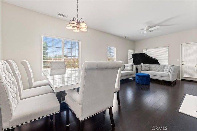 dining area featuring ceiling fan with notable chandelier, dark wood-style flooring, and visible vents