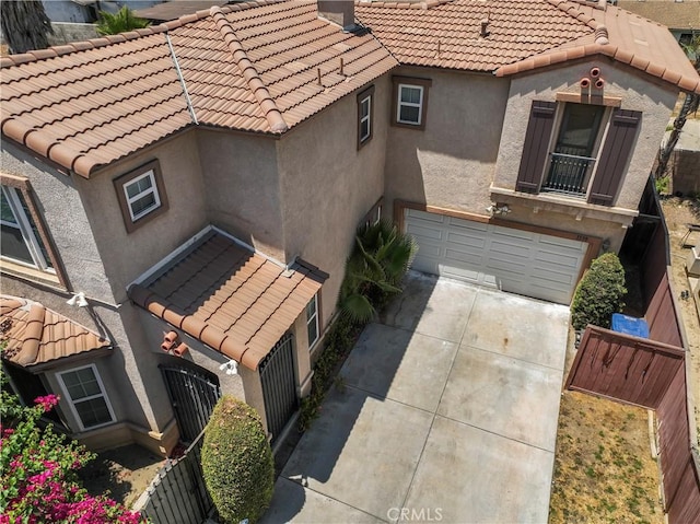 view of home's exterior featuring a garage, a tiled roof, and stucco siding