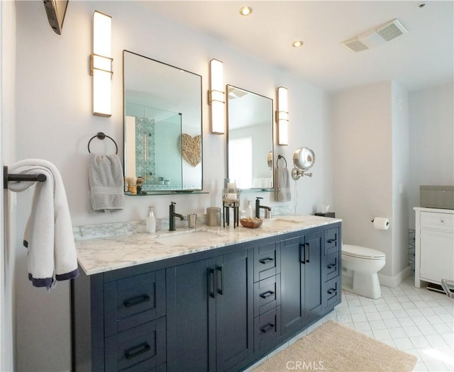 bathroom featuring double vanity, tile patterned flooring, toilet, and a sink