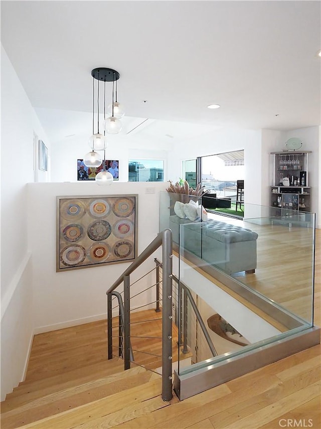 staircase featuring wood finished floors and baseboards