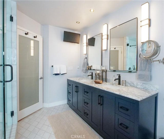 full bathroom featuring double vanity, a stall shower, baseboards, tile patterned flooring, and a sink