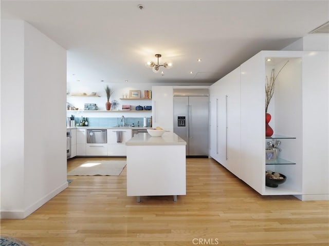 kitchen featuring white cabinets, modern cabinets, stainless steel built in fridge, light countertops, and open shelves