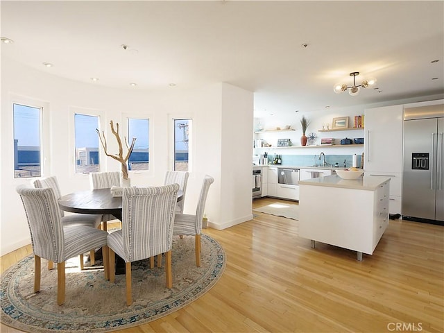 dining room with baseboards, light wood-style flooring, and recessed lighting