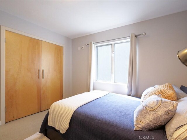 bedroom with a closet and light colored carpet