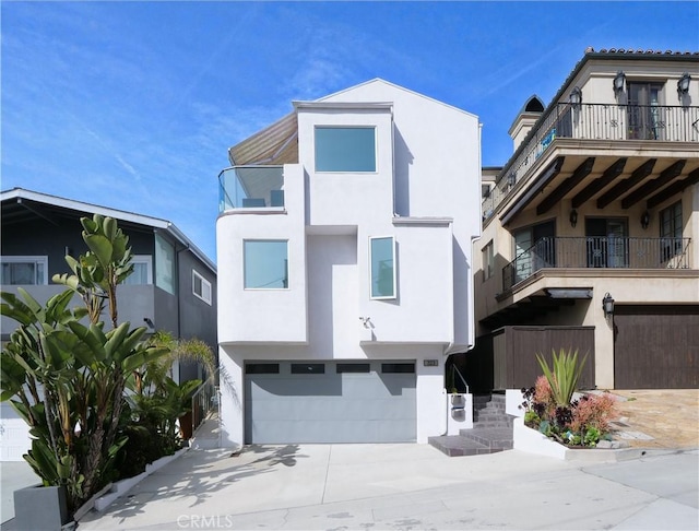 view of front facade featuring a balcony, driveway, a garage, and stucco siding