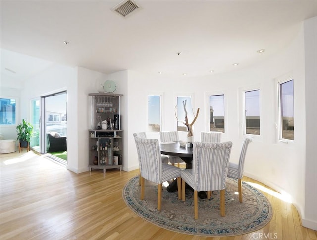 dining area featuring baseboards, light wood-type flooring, visible vents, and recessed lighting