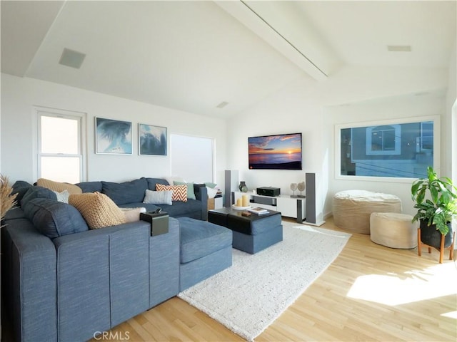 living room featuring vaulted ceiling with beams and wood finished floors