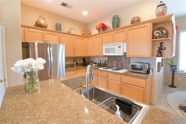 kitchen with a toaster, white appliances, visible vents, and light brown cabinetry