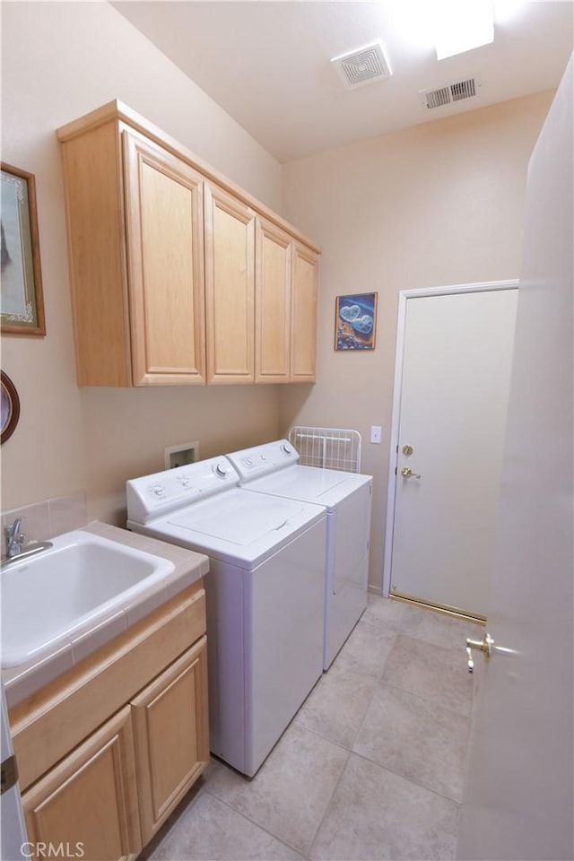 laundry room with visible vents, light tile patterned flooring, cabinet space, and washer and dryer