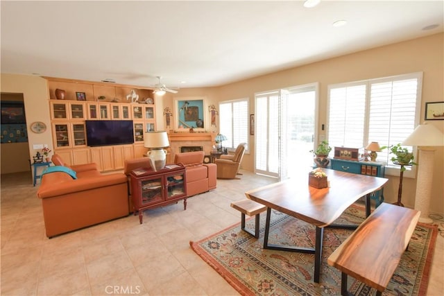 living room with light tile patterned floors, a fireplace, a ceiling fan, and recessed lighting