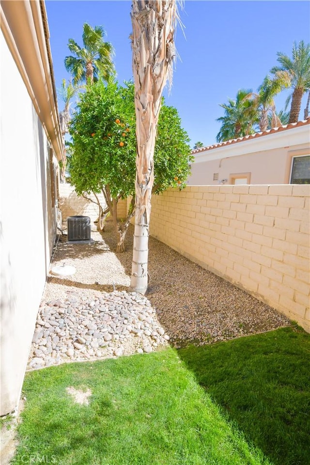 view of yard with a fenced backyard and central AC unit