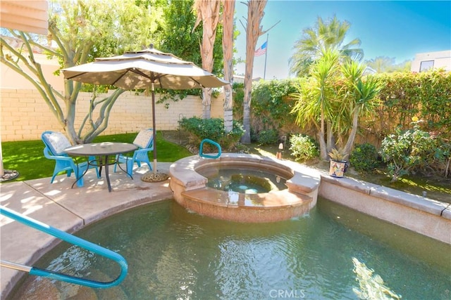 view of pool featuring a pool with connected hot tub, a fenced backyard, and a patio