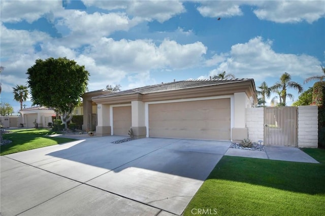 view of front of house with a garage, driveway, a gate, stucco siding, and a front lawn