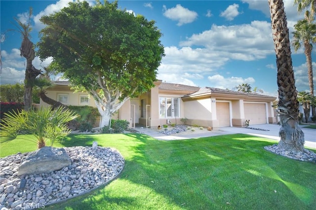 view of front of home featuring an attached garage, driveway, a front yard, and stucco siding