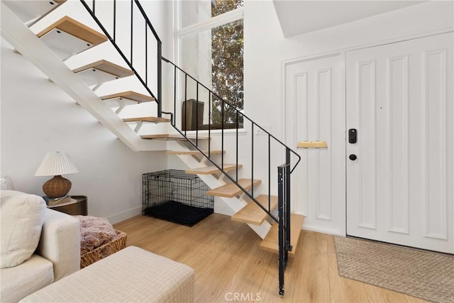 stairs with wood finished floors and baseboards