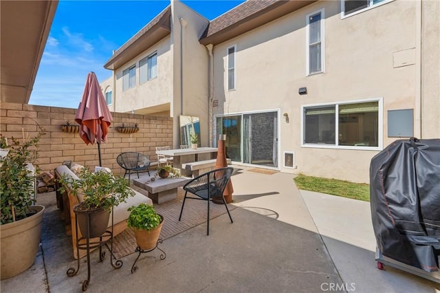 view of patio featuring a grill, fence, and an outdoor living space