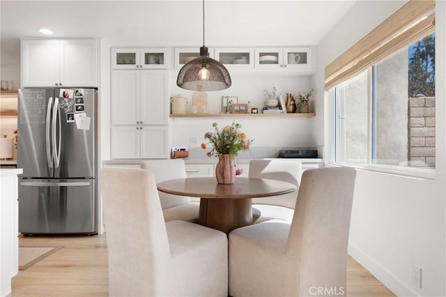 dining area featuring light wood-type flooring and baseboards