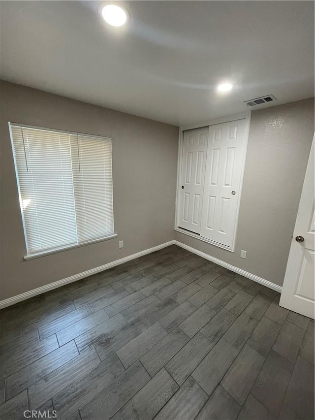 spare room featuring baseboards, visible vents, dark wood finished floors, and recessed lighting