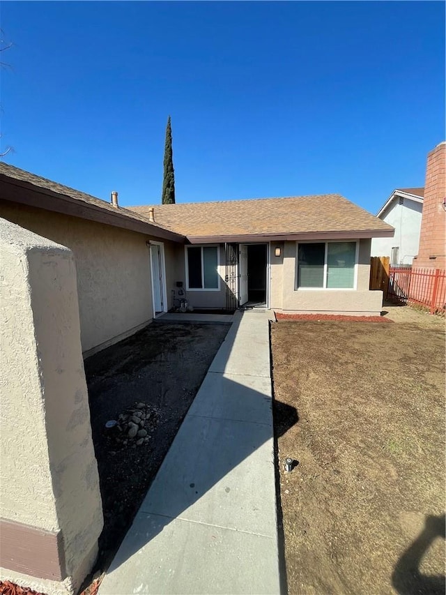 ranch-style home with fence and stucco siding