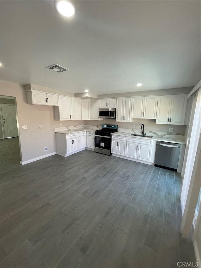 kitchen with stainless steel appliances, light countertops, visible vents, dark wood-type flooring, and white cabinetry