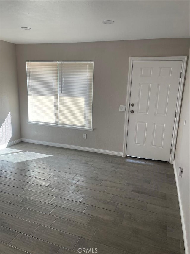 unfurnished room with wood tiled floor and baseboards