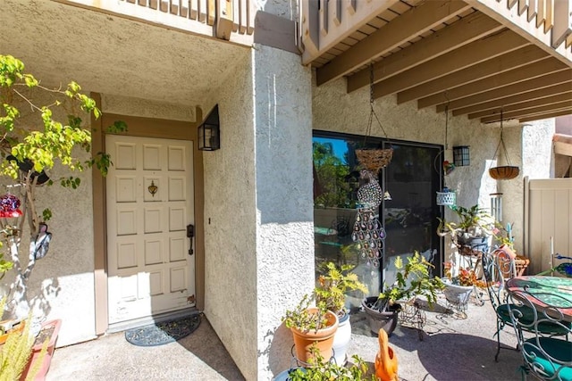 entrance to property featuring a patio and stucco siding