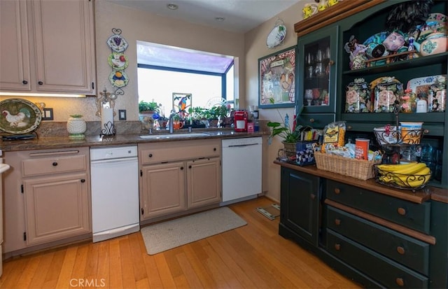 kitchen featuring light wood-type flooring, white dishwasher, and a sink