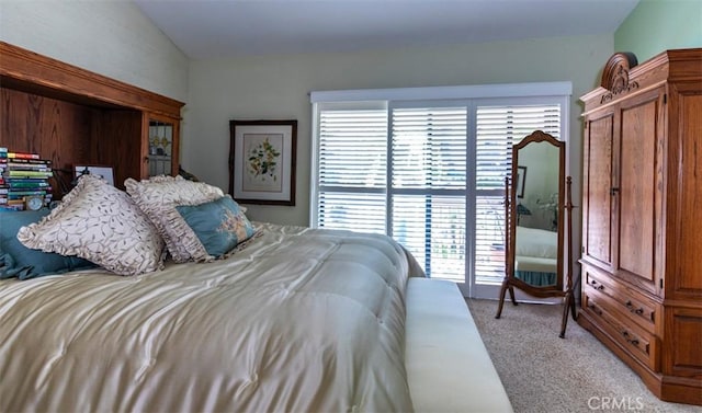 bedroom featuring lofted ceiling and light colored carpet